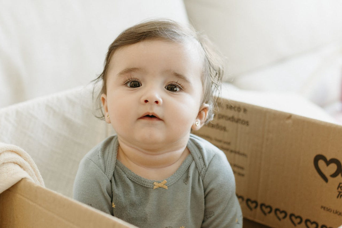 bébé de 6 mois jouant dans un carton