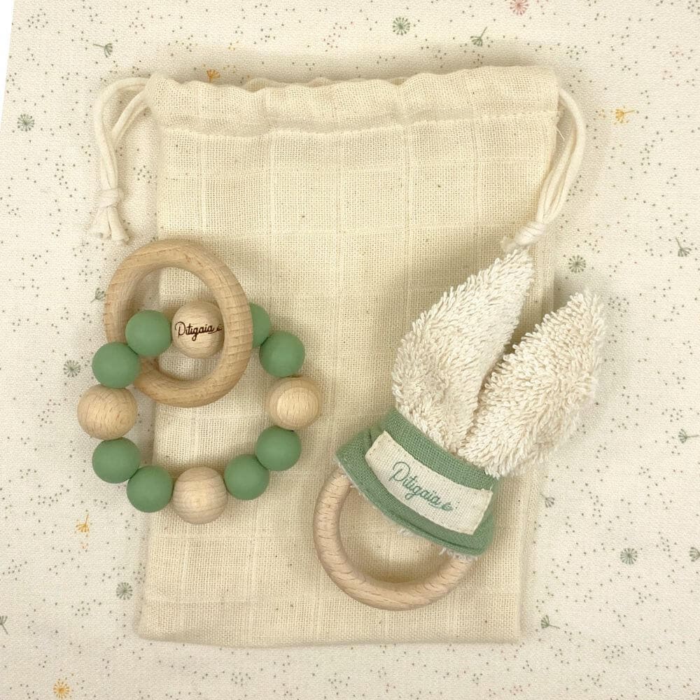 anneau et hochet de dentition bois silicone coloris vert présentés posés sur un pochon beige parfait cadeau de naissance