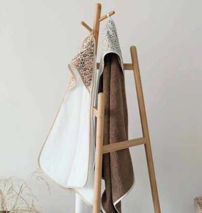 cape de bain bébé suspendue sur un porte-manteau en bois