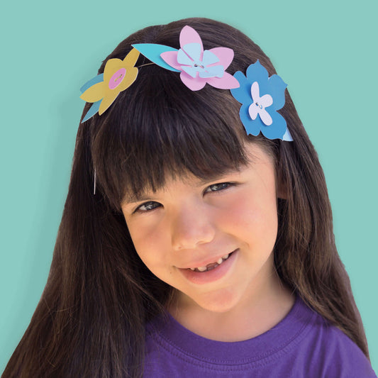 petite fille souriante portant la couronne de fleurs en papier qu'elle a fabriqué durant une activité anniversaire 5 ans