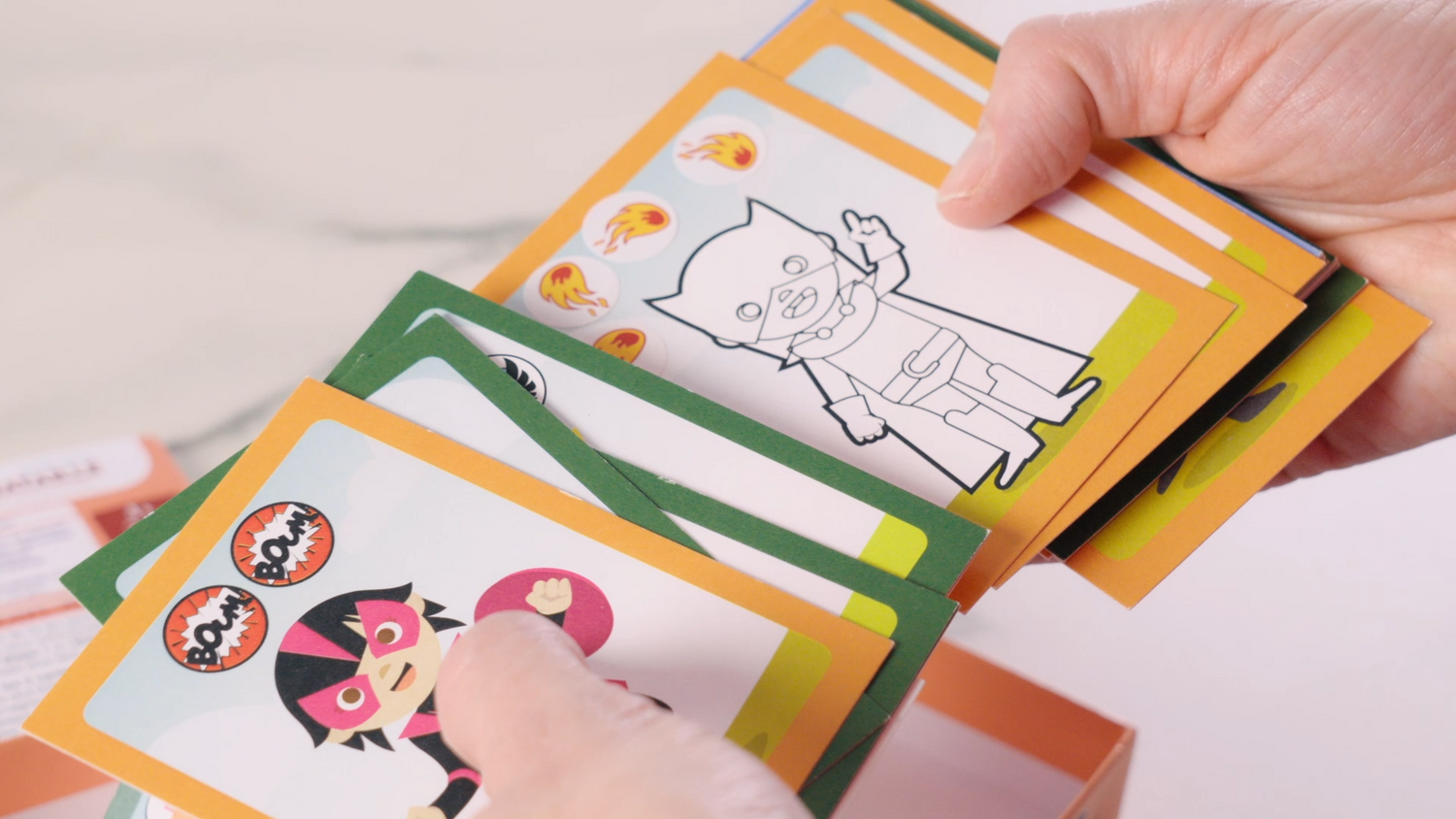 mains tenant des cartes du jeu de bataille créatif Coq6grue pour enfants de 4 ans