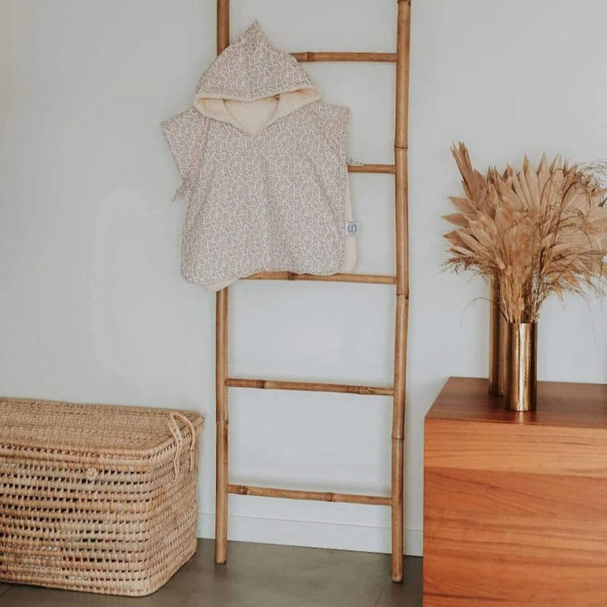 joli poncho de bain fleuri pour bébé et jusqu'à 3 ans suspendu à une échelle en bois