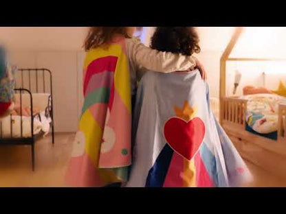 2 petites filles de 7 et 4 ans déguisées avec des capes de super héroïnes et marchant de dos